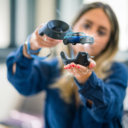 A woman interacs with a miniature car in augmented reality.