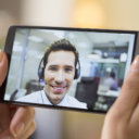 Closeup of a female hand holding a smart phone during a skype vi